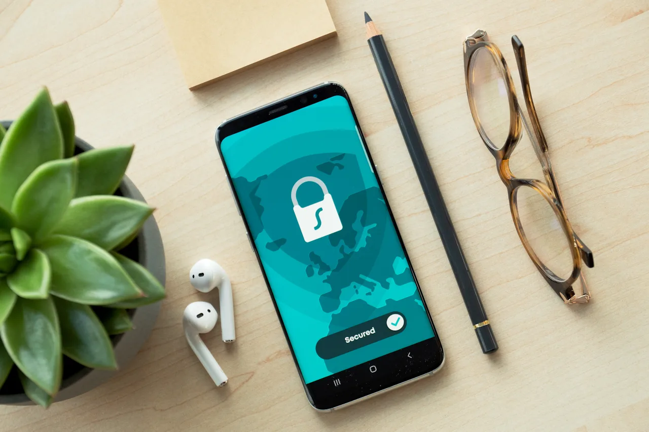Smartfon z ikoną kłódki na ekranie leżący na biurku – symbol bezpieczeństwa kont w social media